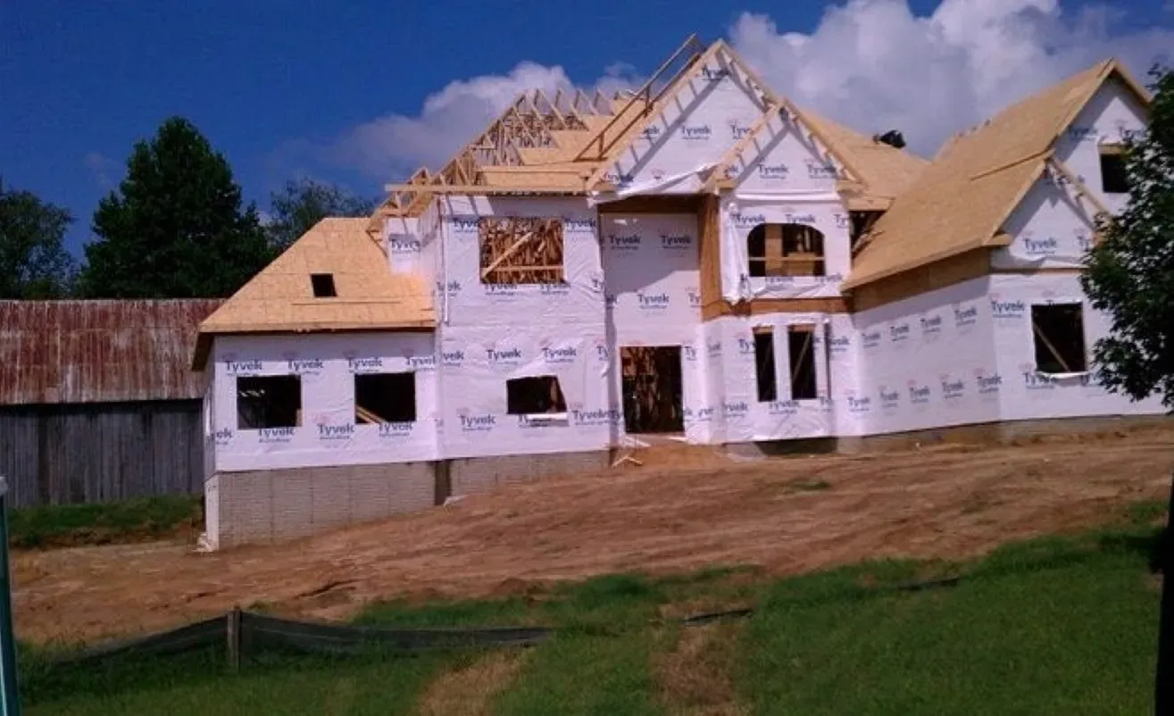 A large house is being built in the middle of a field