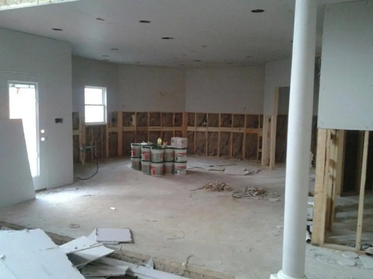 A room under construction with buckets of paint on the floor