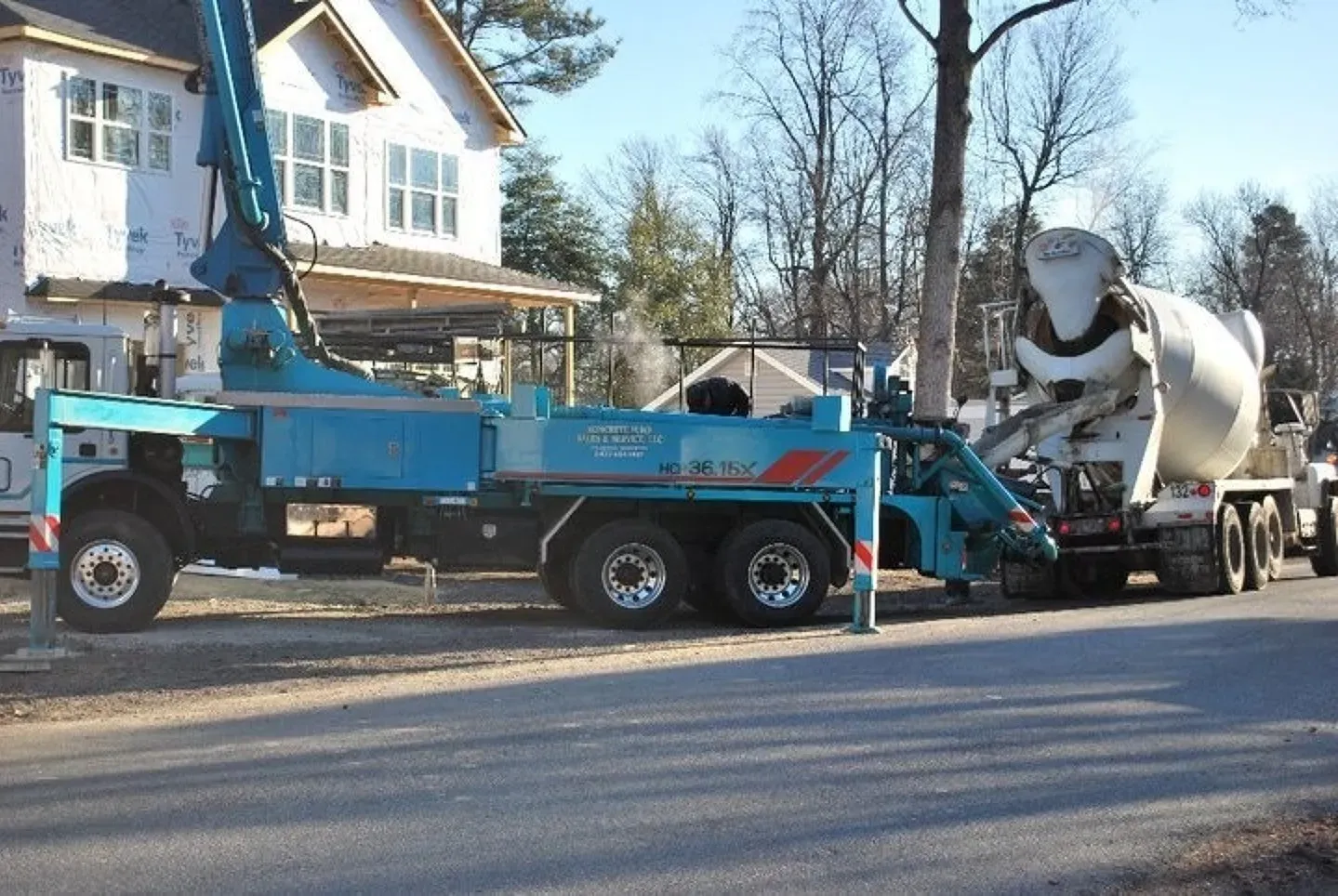 A concrete pump truck is parked next to a mixer truck