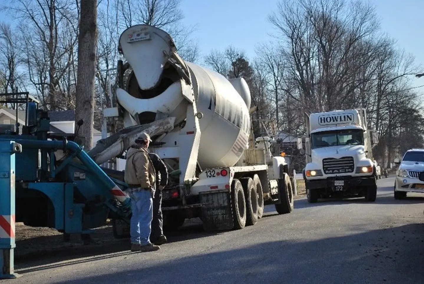 A man stands next to a mixer truck that says biomix