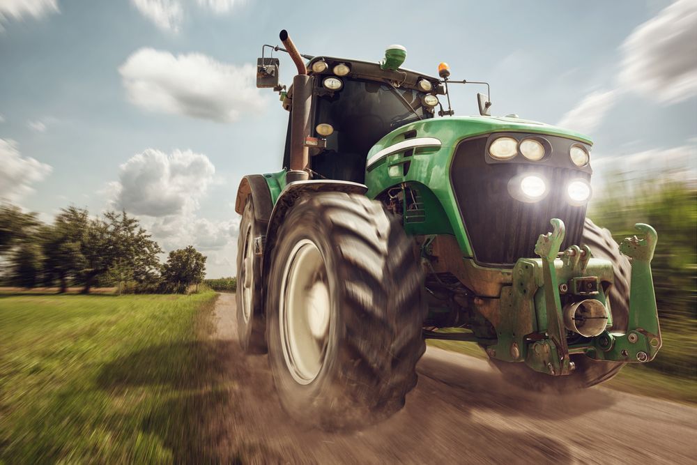 A Green Tractor is Driving Down a Dirt Road — LJE MechanicaI Gilgandra, NSW