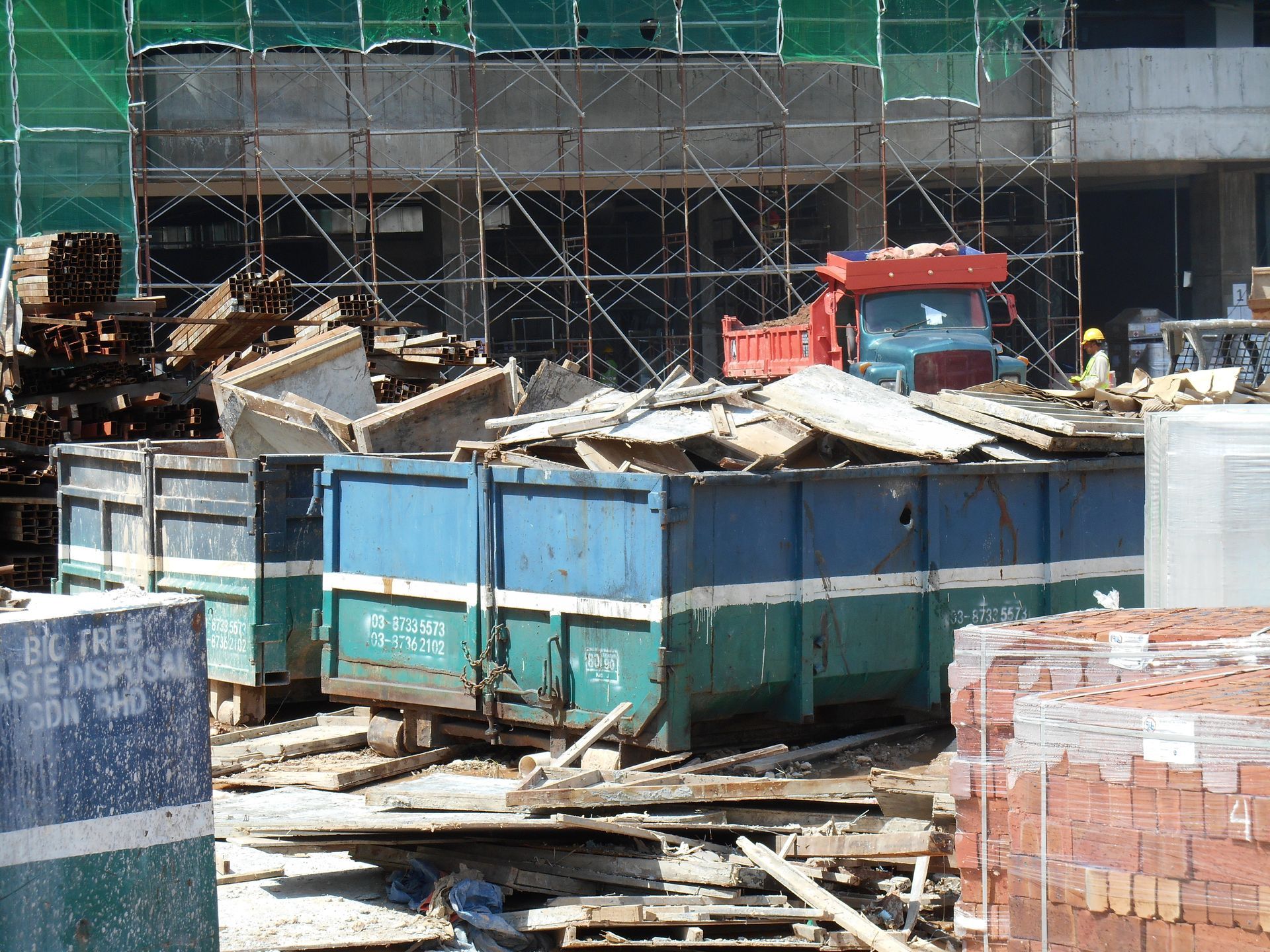 A dump truck is parked in front of a building under construction