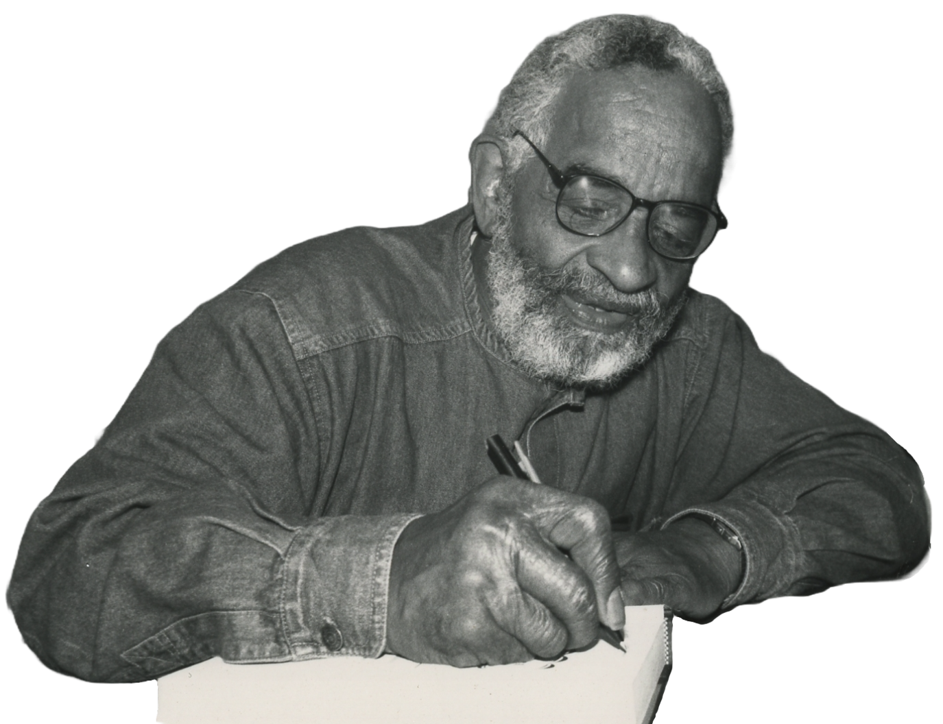 Nelson Peery writing with a pen, leaning over a paper stack