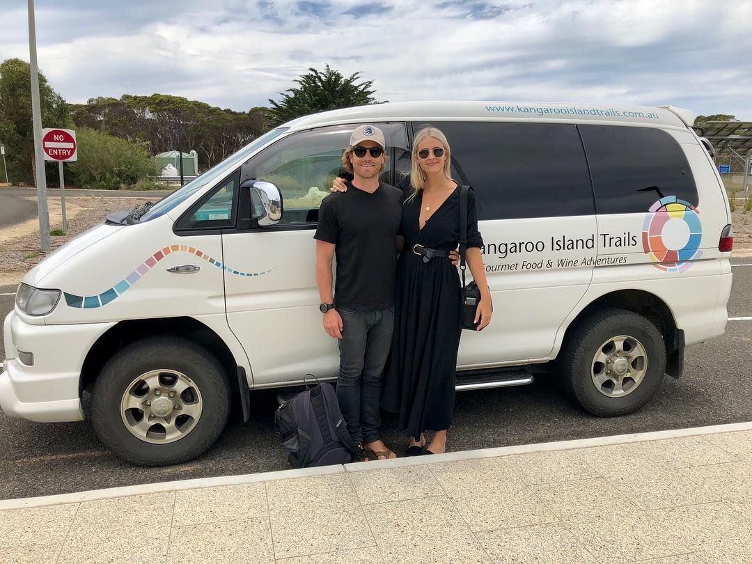 A couple stands by a white van with Kangaroo Island Tours