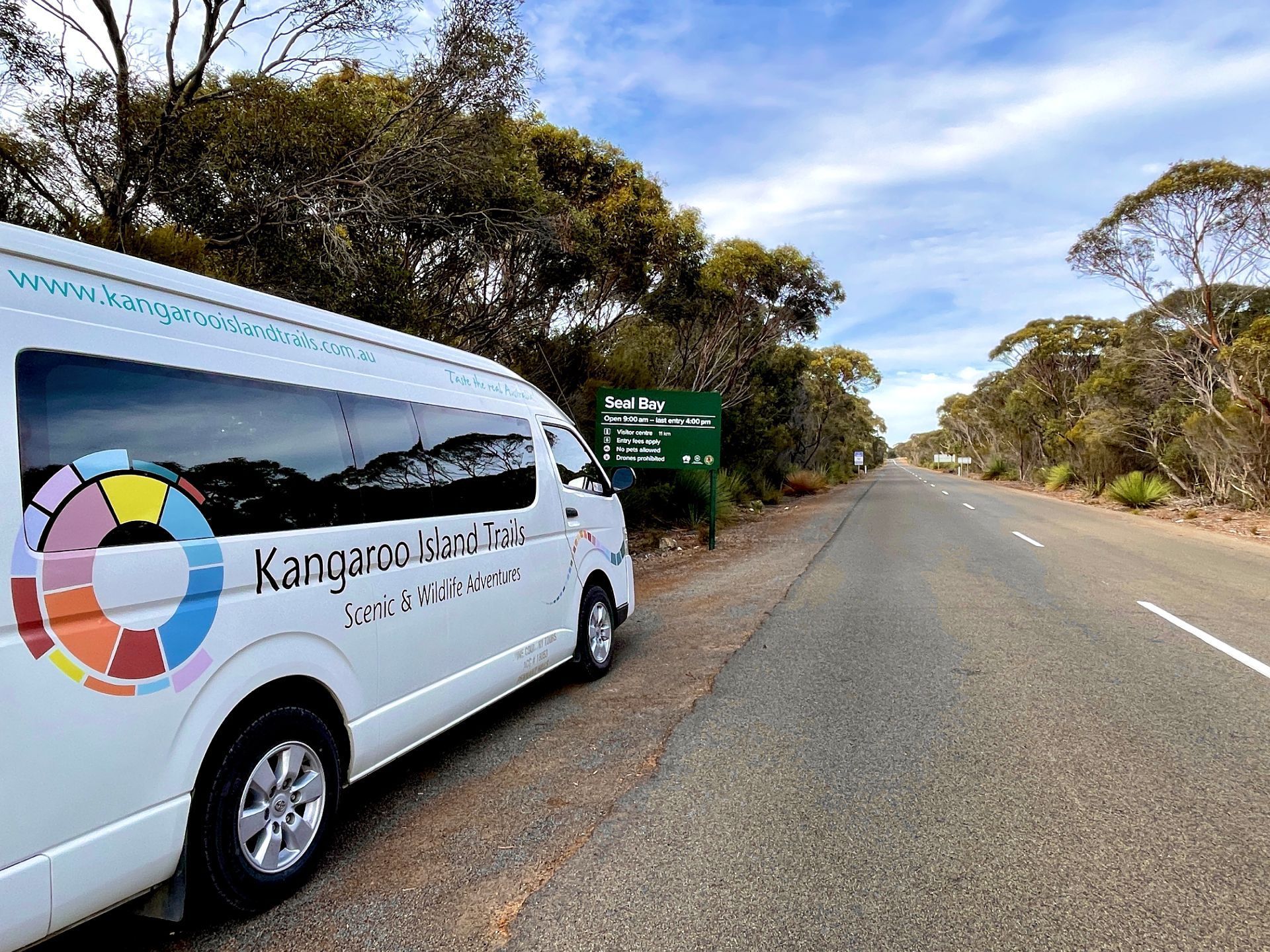 White tour van parked on roadside