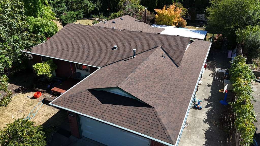 Aerial of the finished brown Malarkey shingle roof on a Clackamas, OR home among green trees