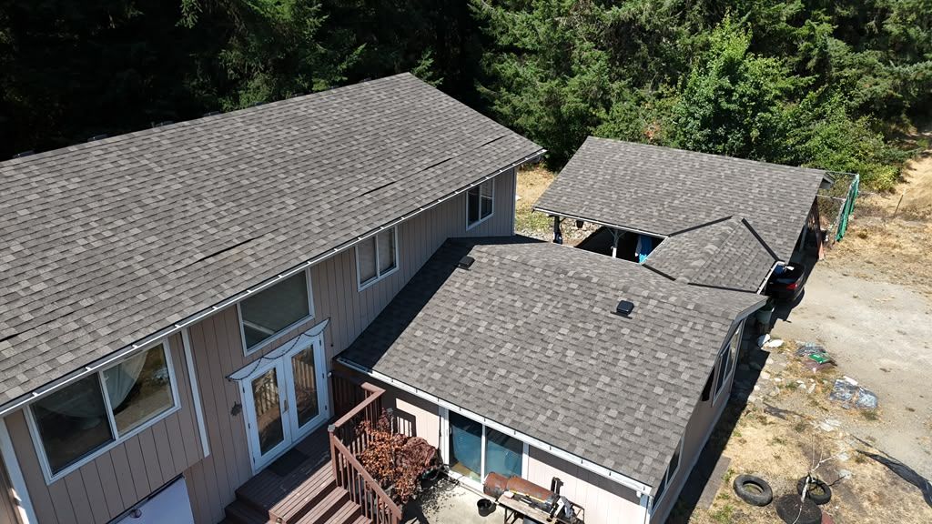 Aerial of the completed dark shingle roof across the main house and adjoining sections