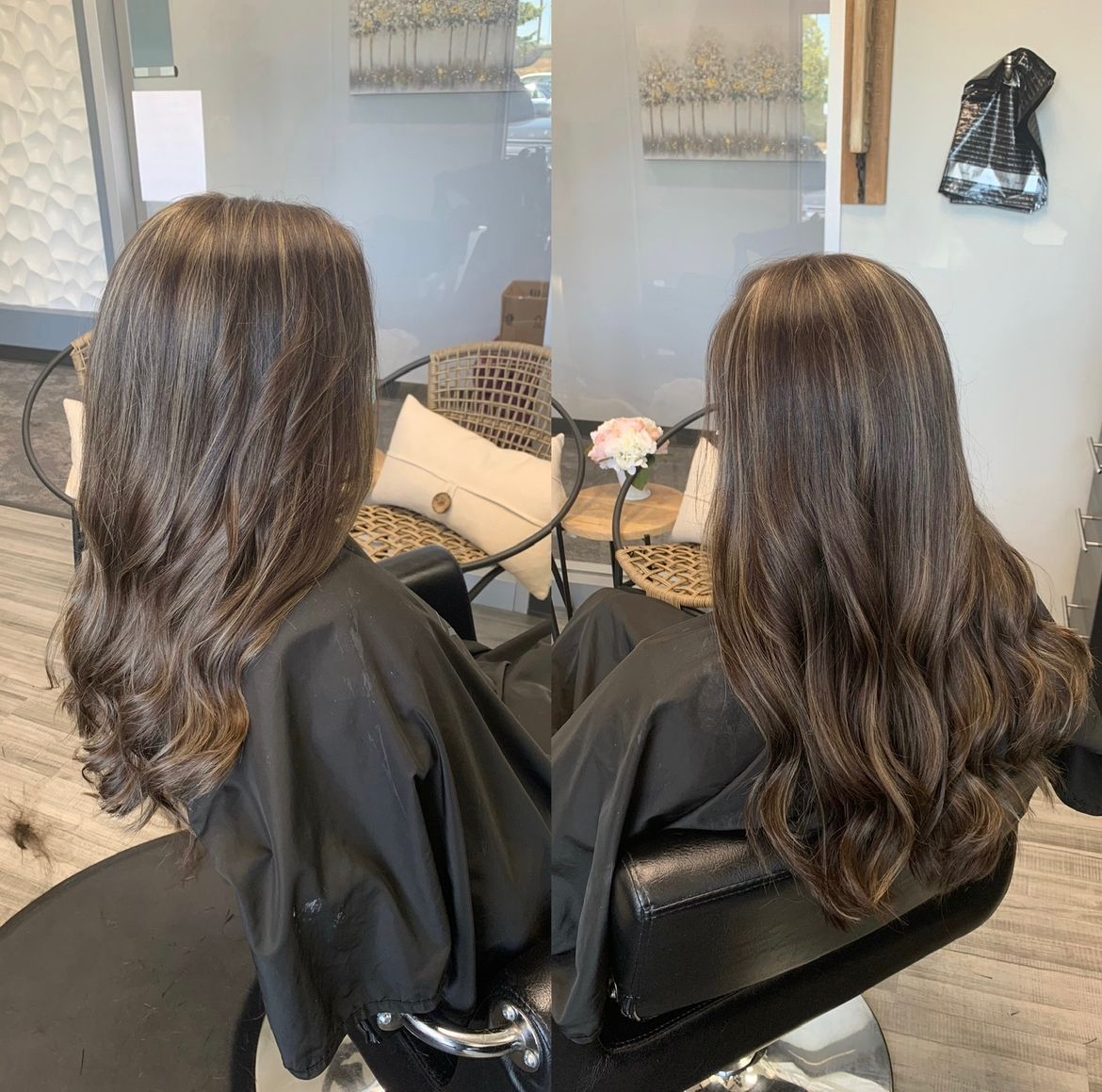 Two women with long hair are sitting in a chair in a salon.