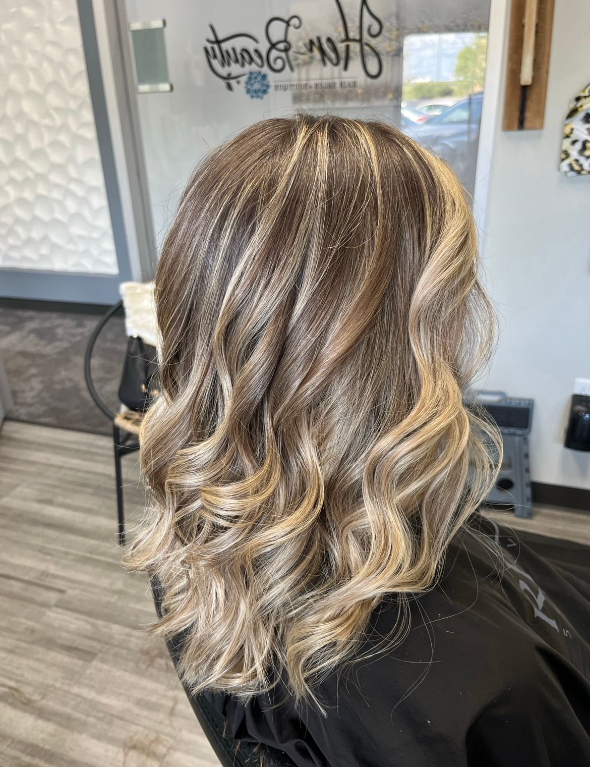 A woman with blonde hair is sitting in a chair in a salon.