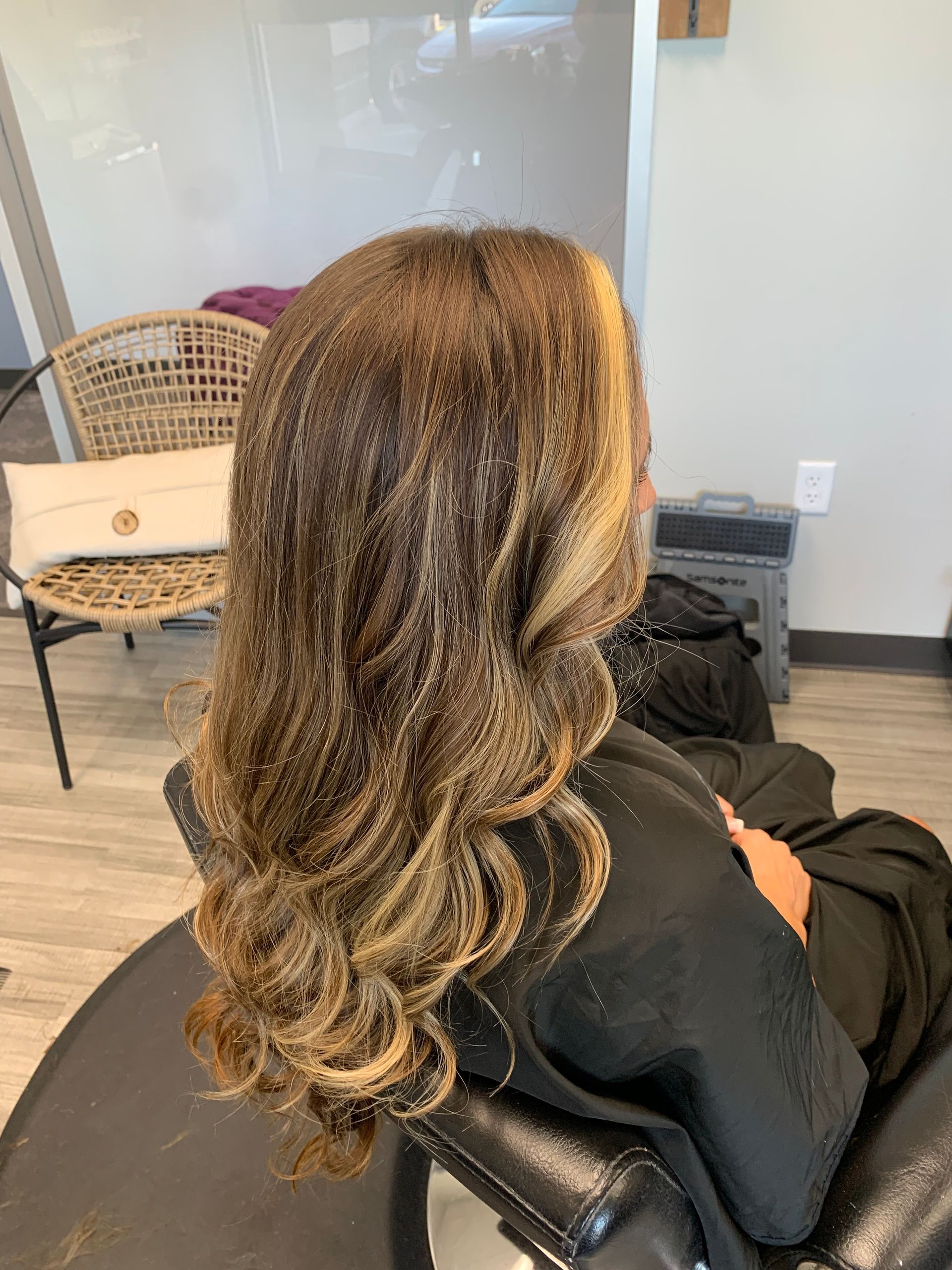A woman is sitting in a chair with her hair in a ponytail.