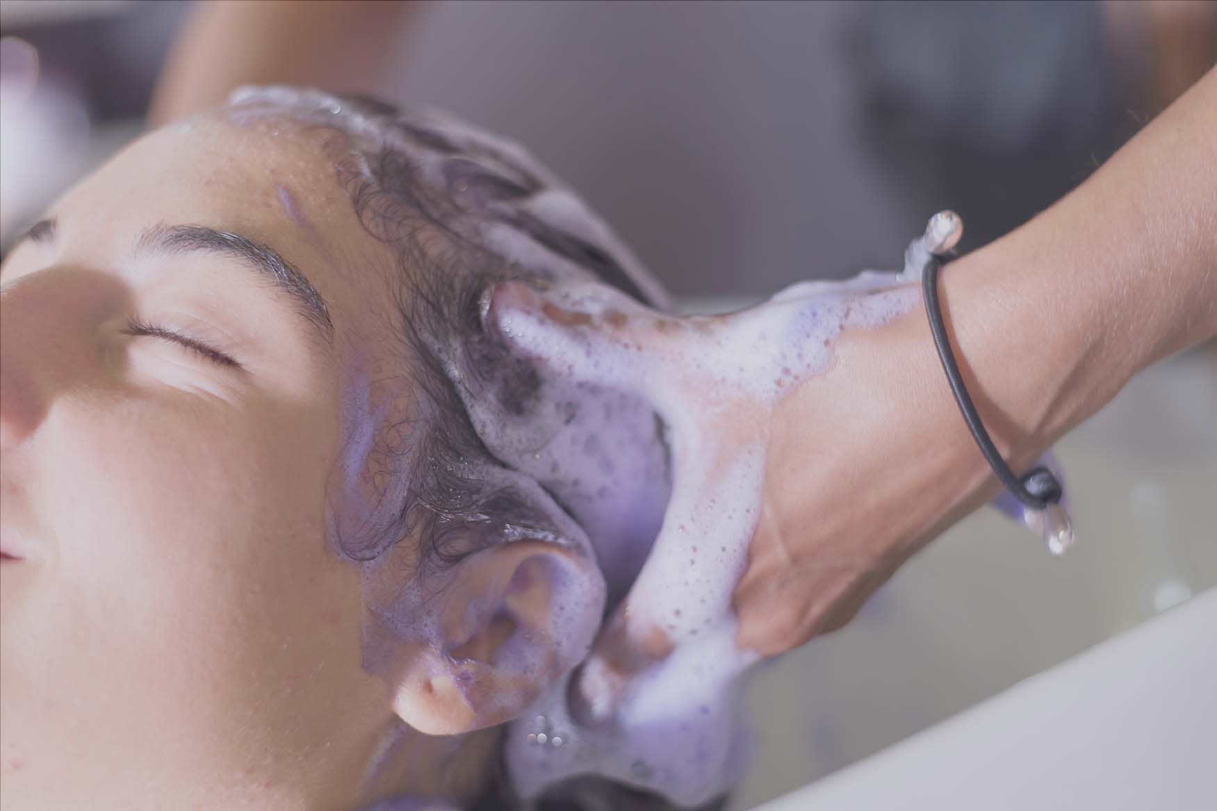 A woman is getting her hair washed in a salon.