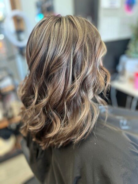 A woman is getting her hair cut in a salon.