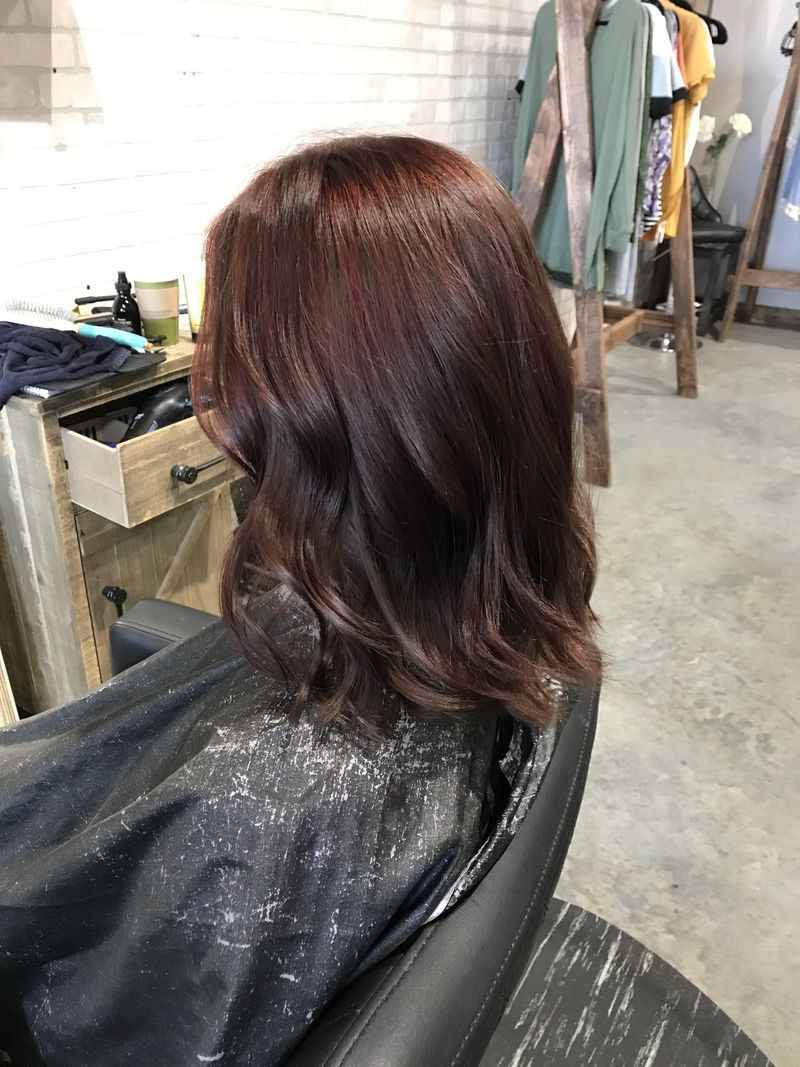 A woman is sitting in a chair with her hair dyed in a salon.