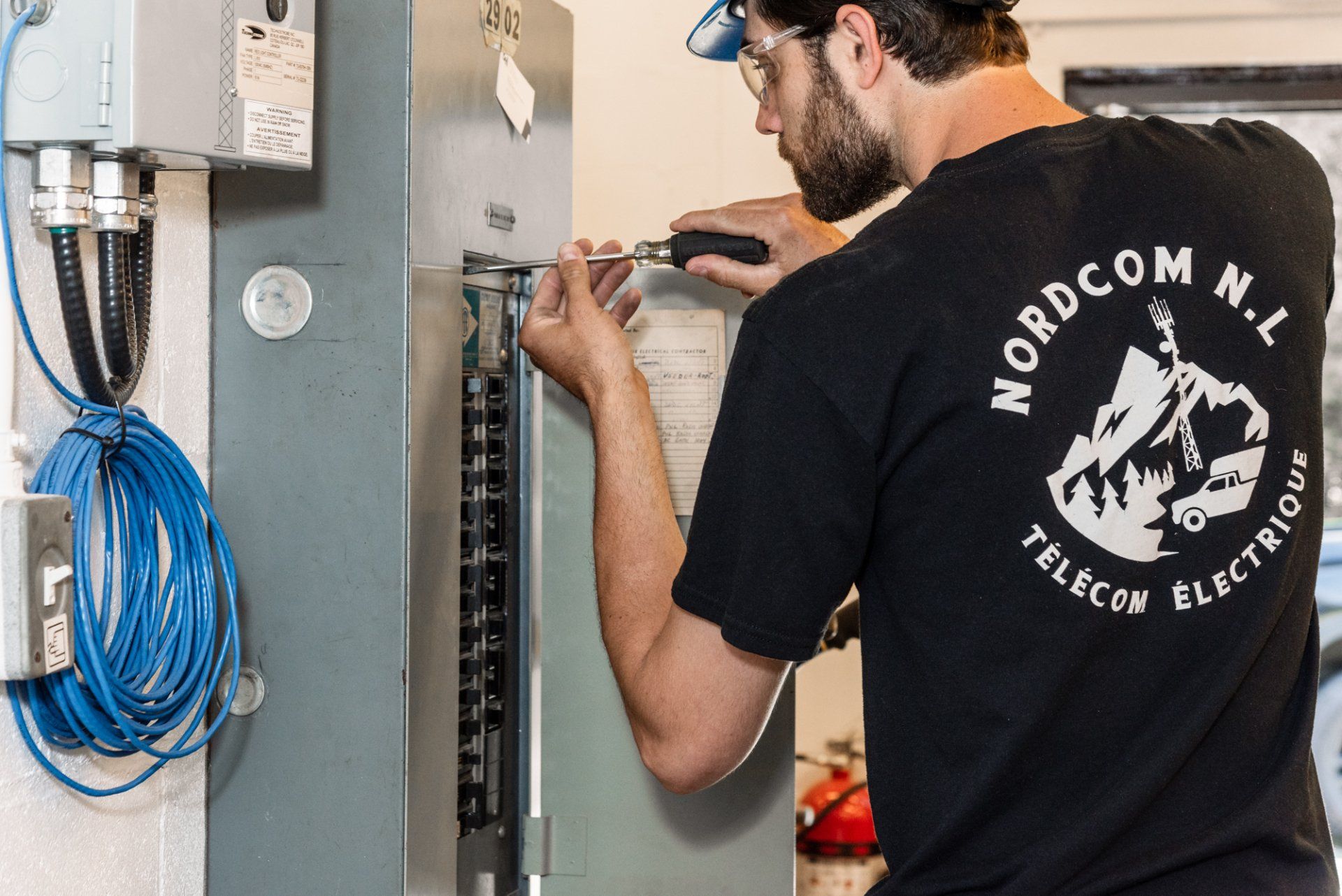 electricien travaillant sur un panneau électrique
