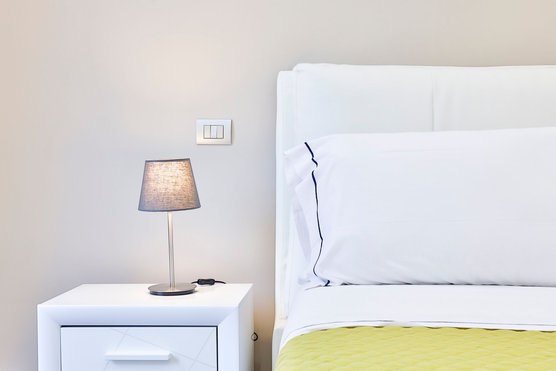 Camera da letto con un letto e un comodino con sopra una lampada