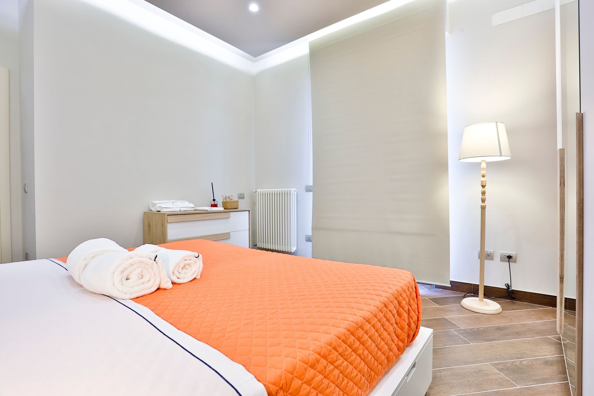 Camera da letto con un letto grande e una lampada.