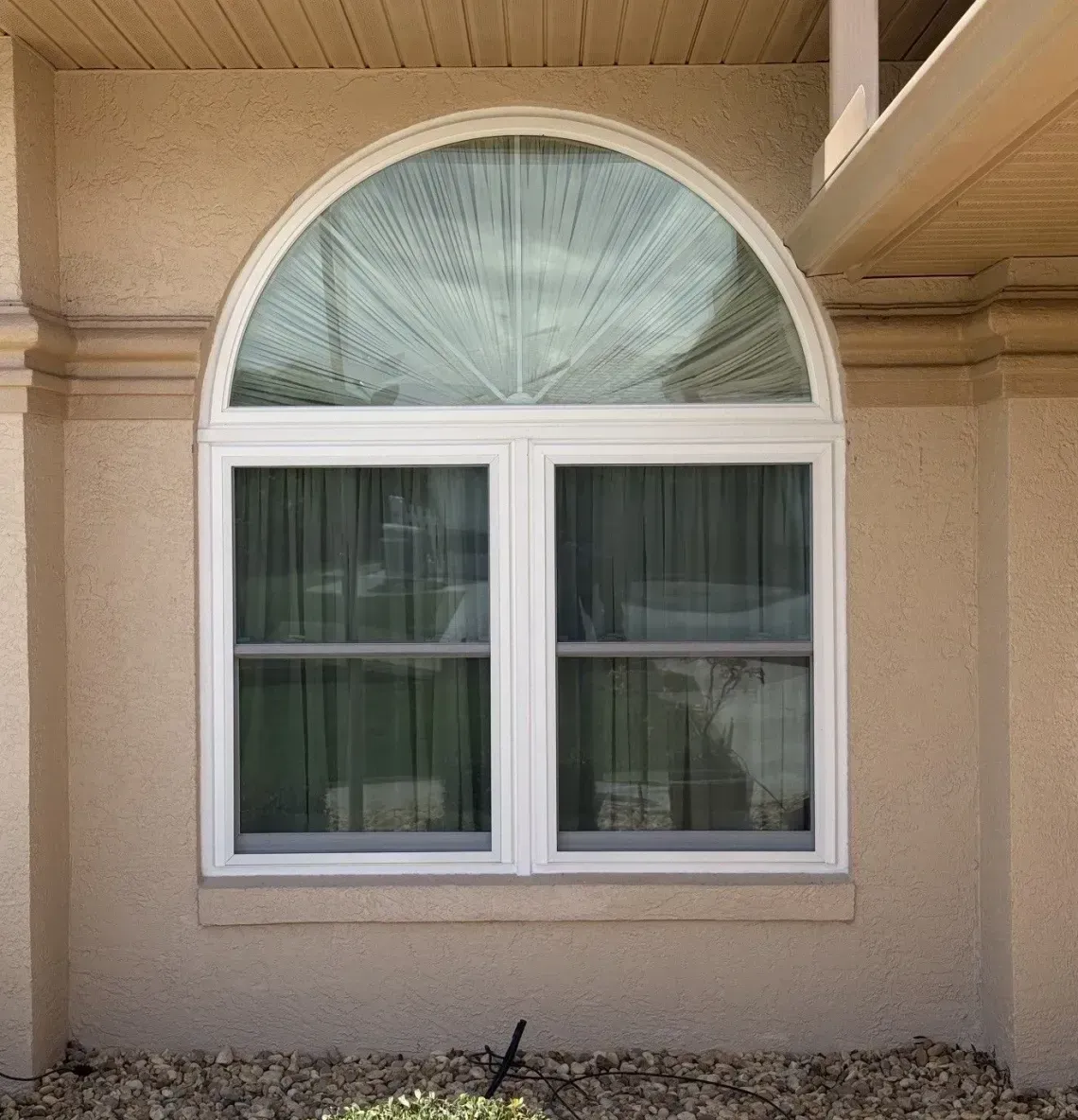 Person carrying a window frame through a doorway in a bright room
