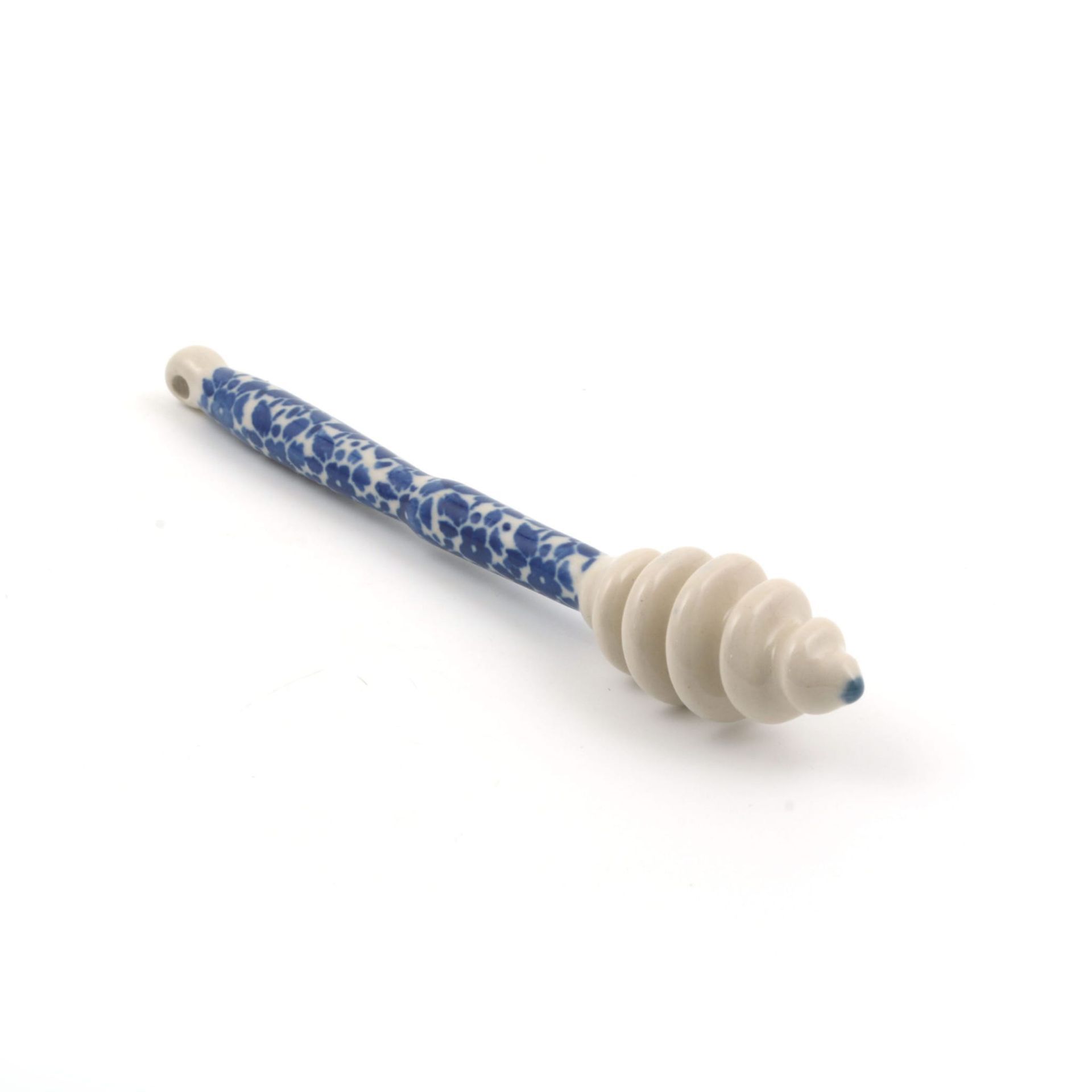 Honinglepel van keramiek met een wit en blauw patroon.
