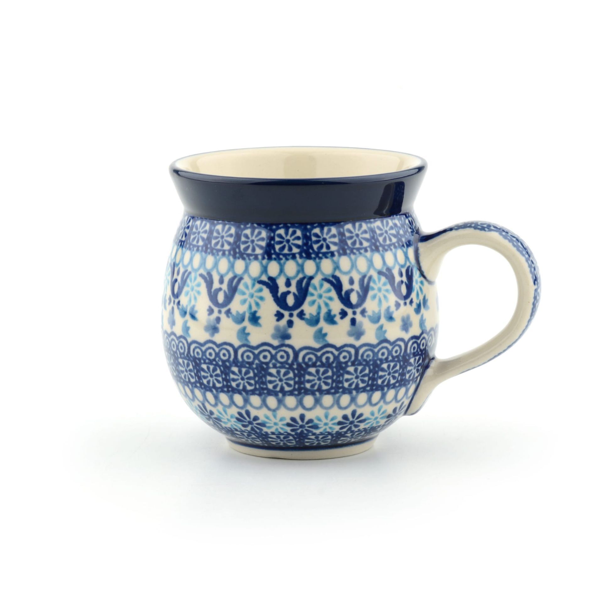 Blauw-witte keramische mok met bloemenpatroon, donkerblauwe rand en crèmekleurige binnenkant, op een witte achtergrond.