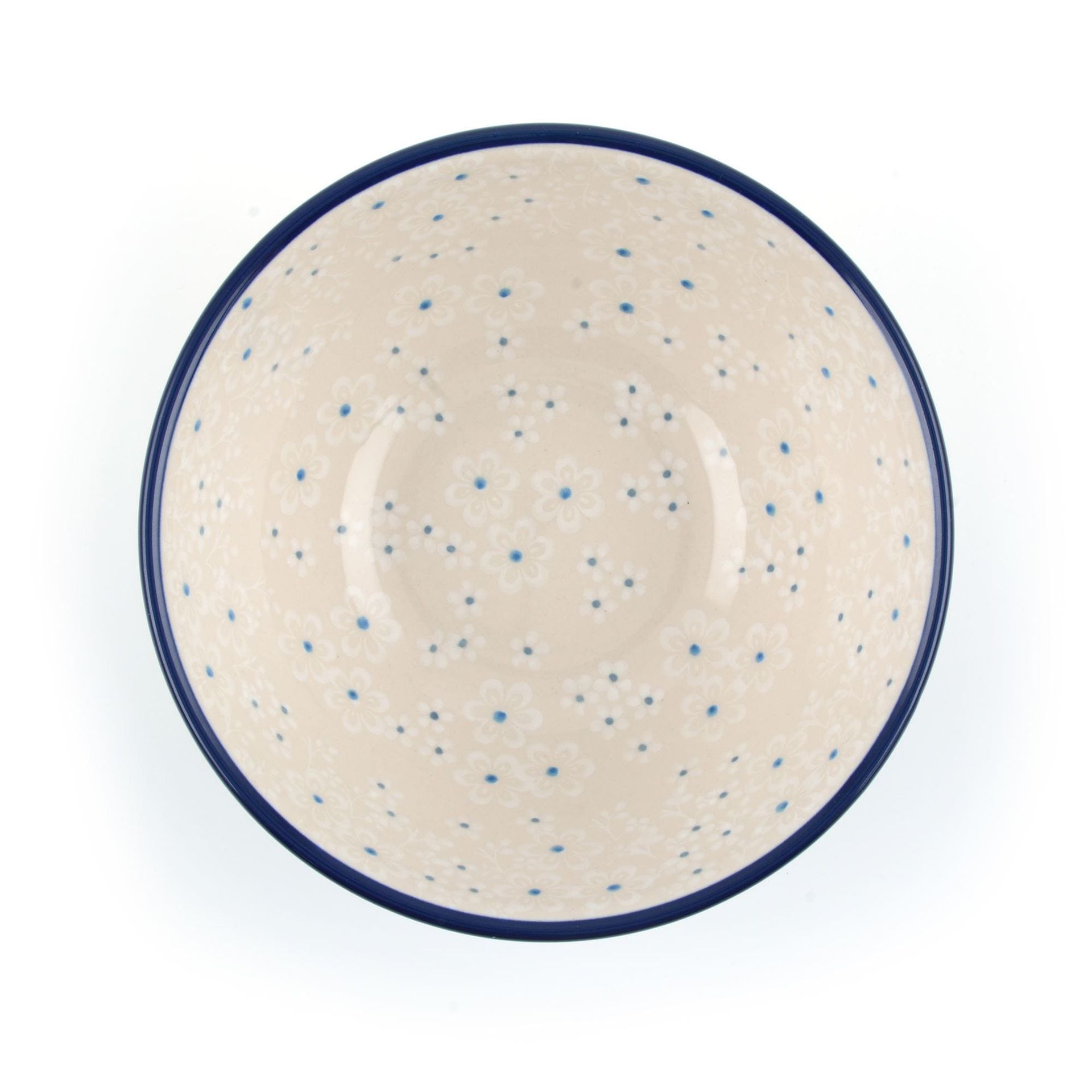 Crèmekleurige kom met een blauw gespikkeld patroon en een donkerblauwe rand.