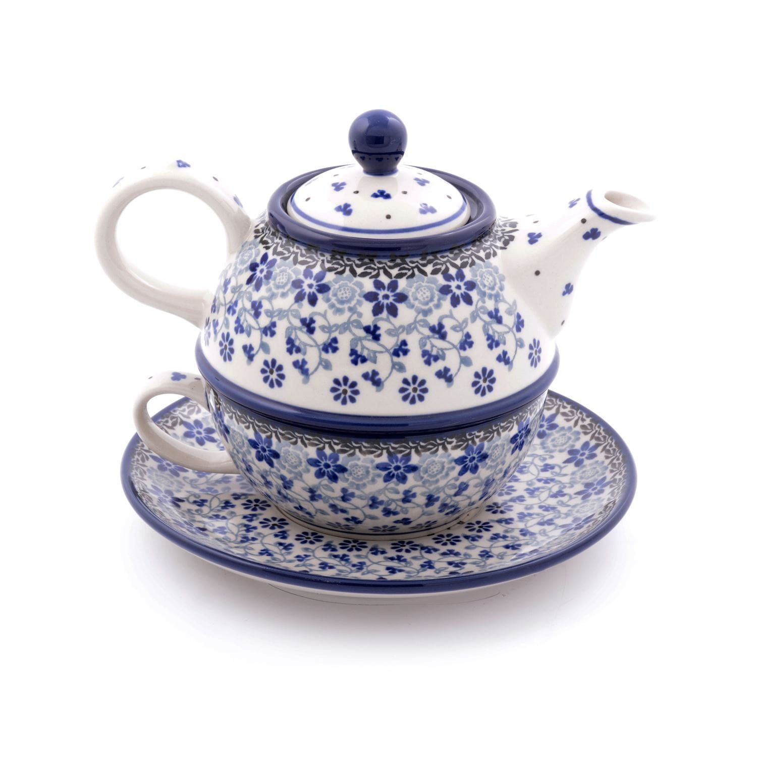 Keramische theepot, kopje en schotelset met blauw bloemenpatroon op een witte achtergrond.