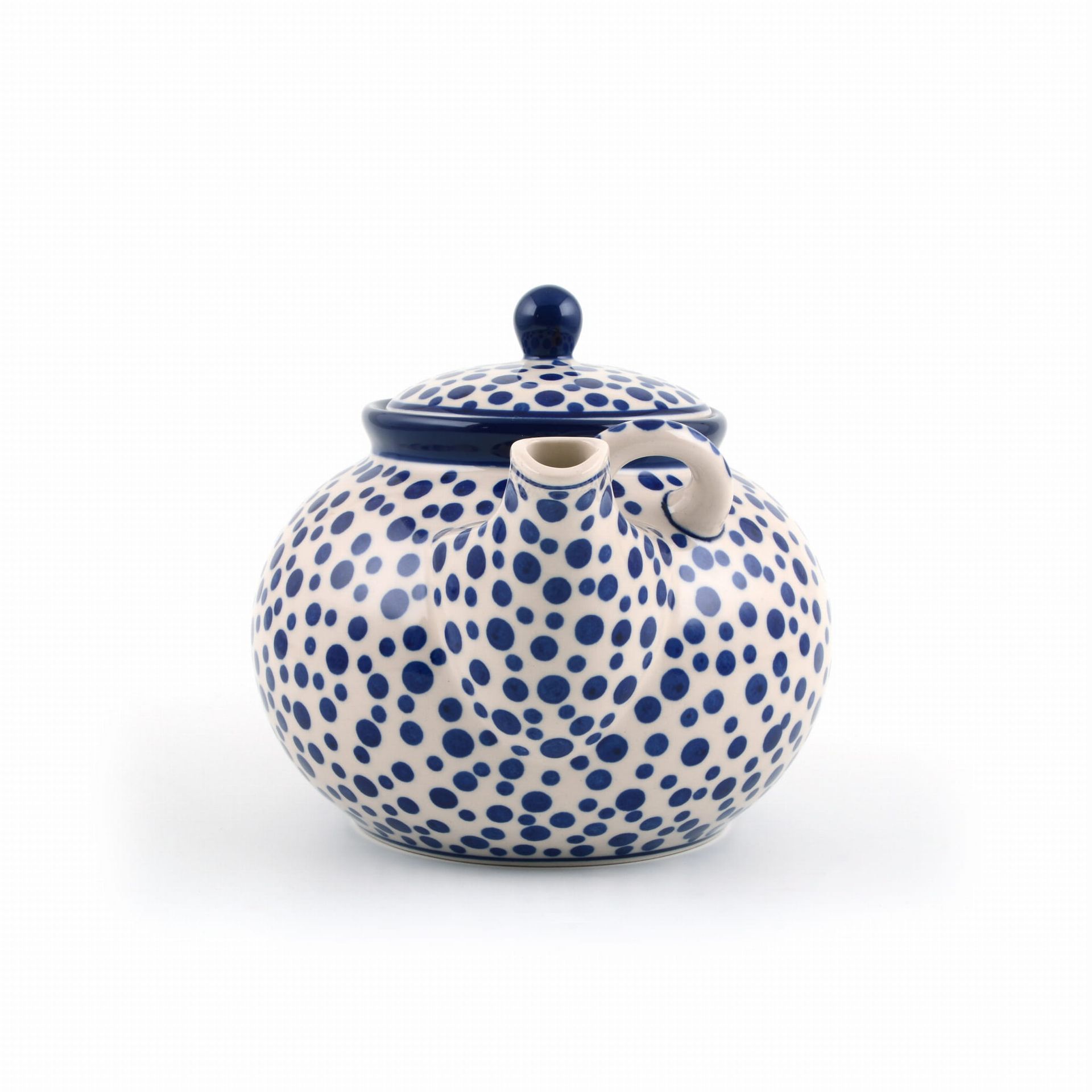 Keramische theepot met blauwe stippen op een witte achtergrond, handvat, tuit en deksel.
