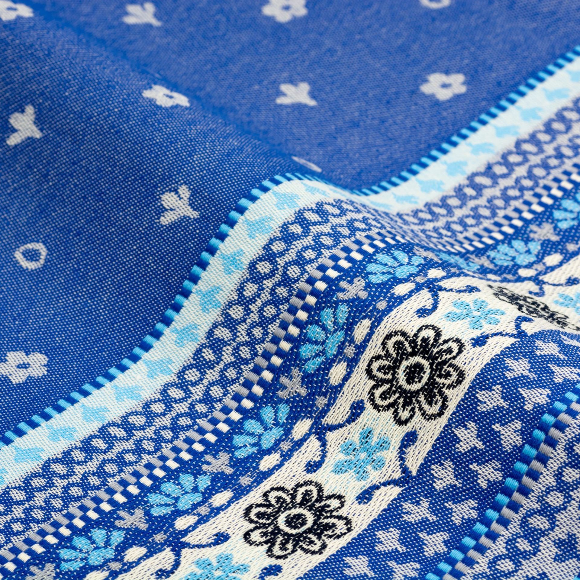 Een handdoek met blauw-wit patroon hangt aan een donkere haak.