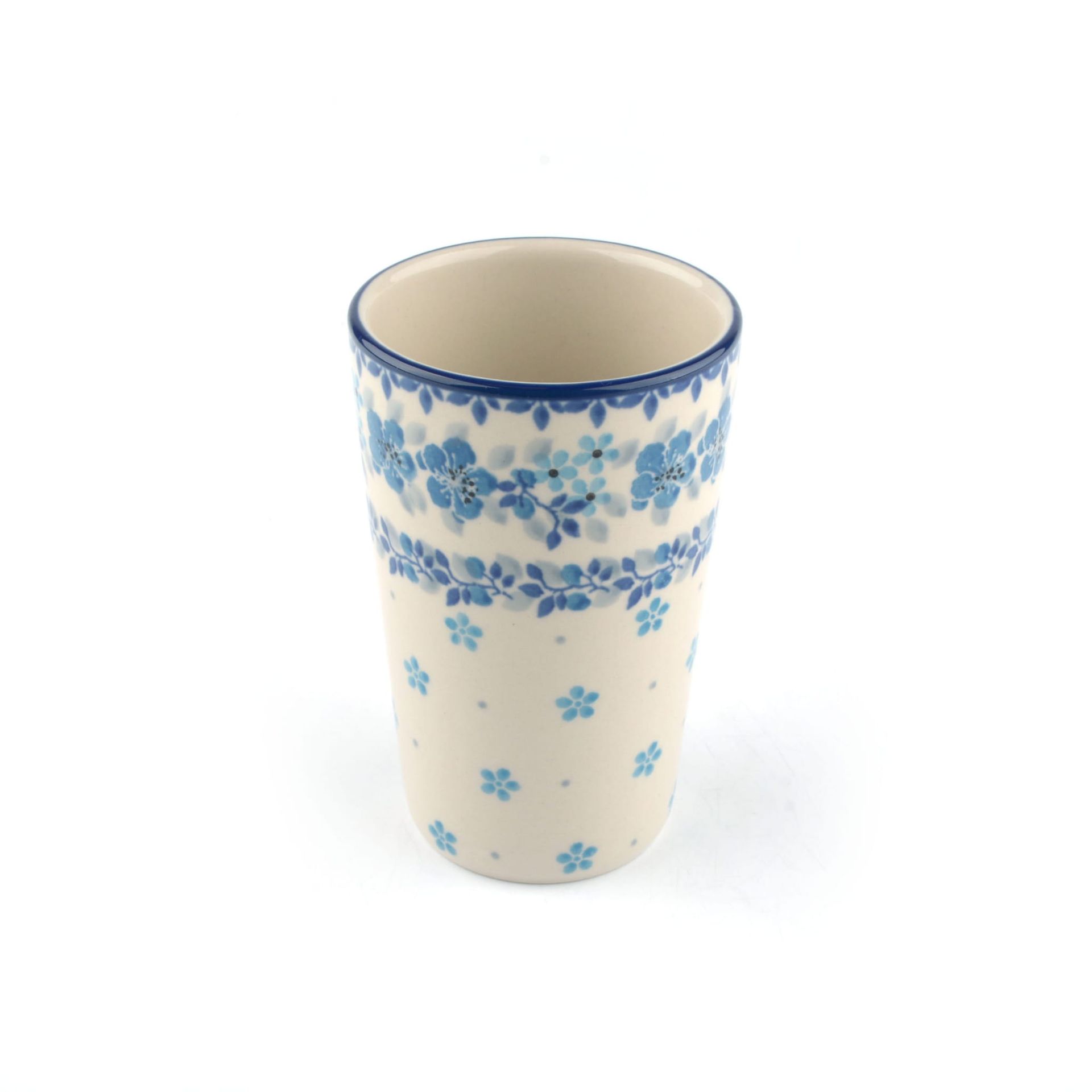 Hoge keramische mok met blauw bloemenpatroon op een crèmekleurige achtergrond.