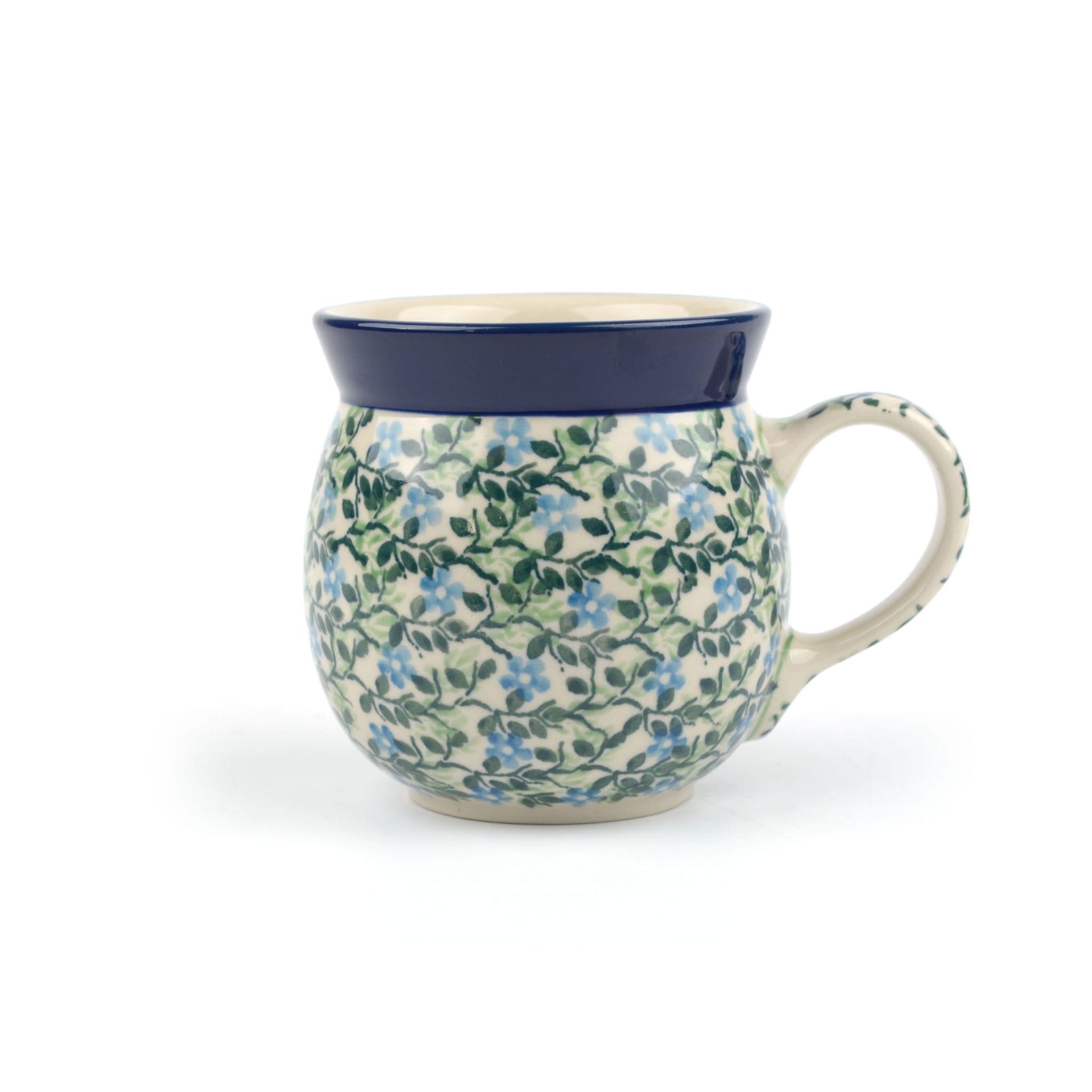 Ronde keramische mok met bloemenpatroon, donkerblauwe rand en handvat.