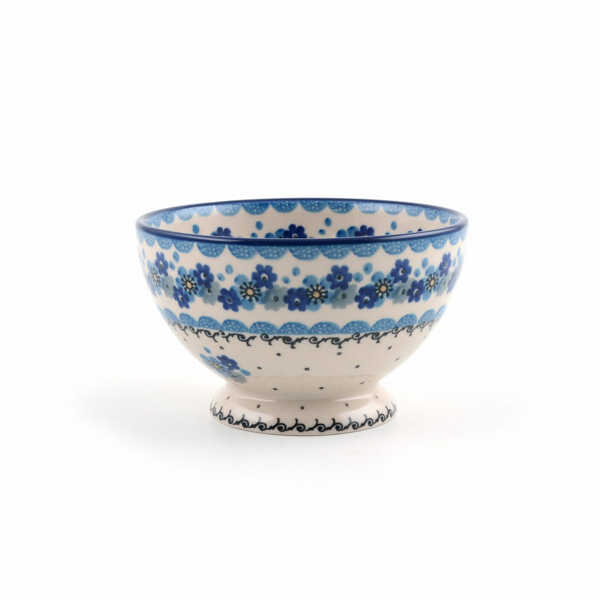 Keramische kom met blauw bloemenmotief en geschulpte rand. Witte achtergrond.