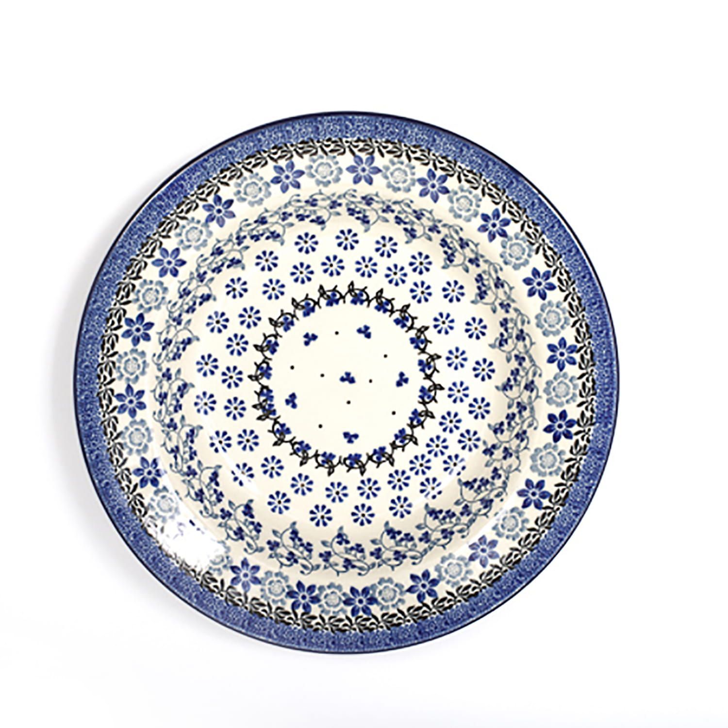 Blauw-wit bord met bloemenpatroon op een witte ondergrond.