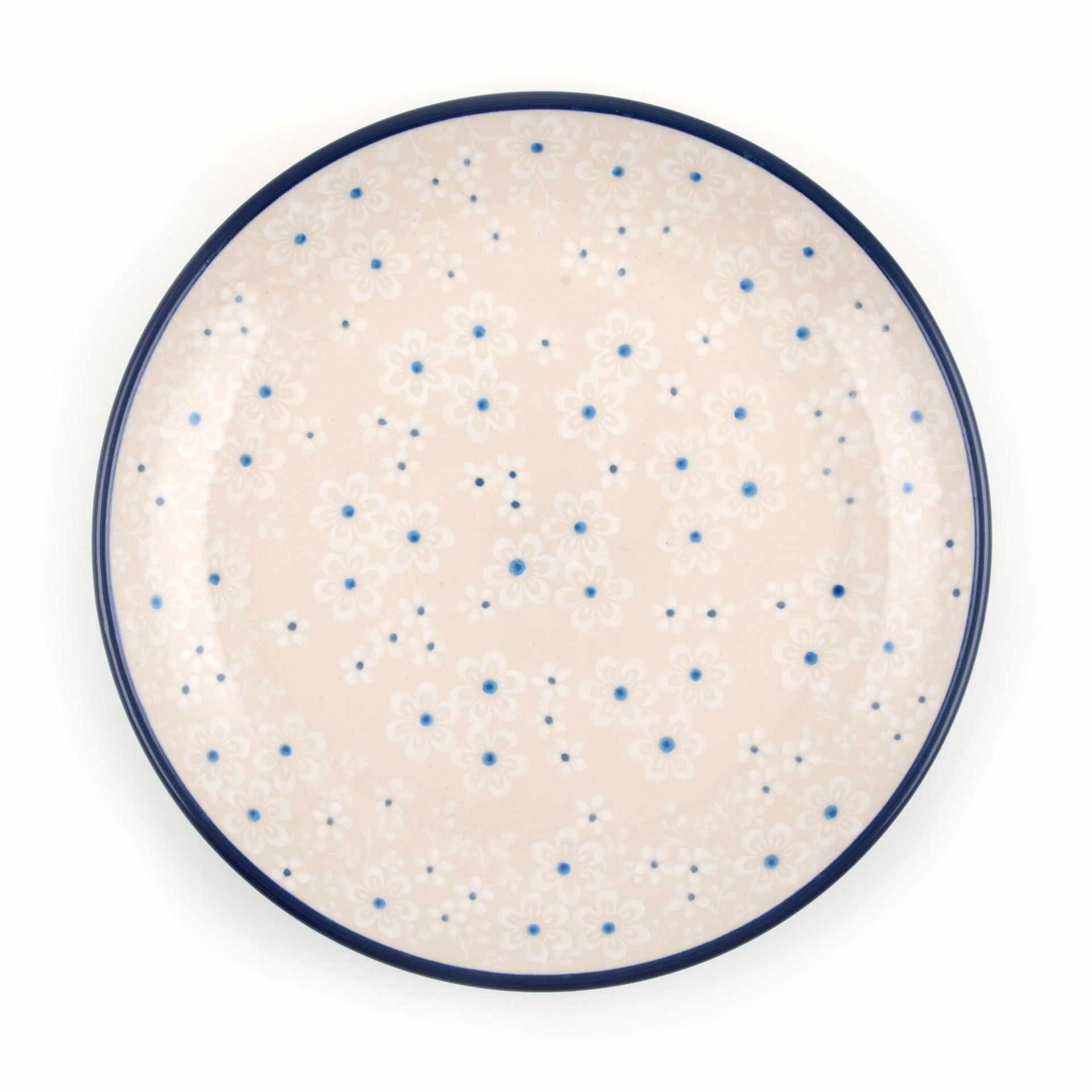 Wit bord met een blauwe rand en een patroon van kleine witte bloemen en blauwe stippen.
