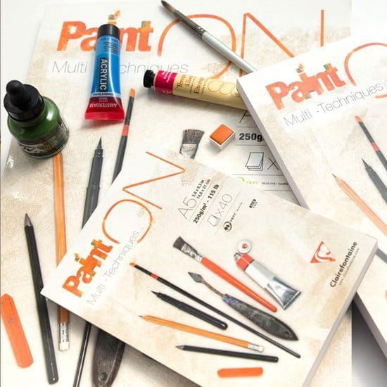 Omslag van een Paint ON tekenblok, A4-formaat, met afbeeldingen van tekenbenodigdheden en verfspatten.