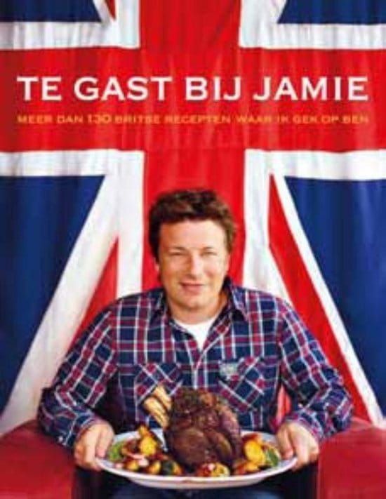 Jamie Oliver met een bord eten in zijn handen, zittend voor een Britse vlag.