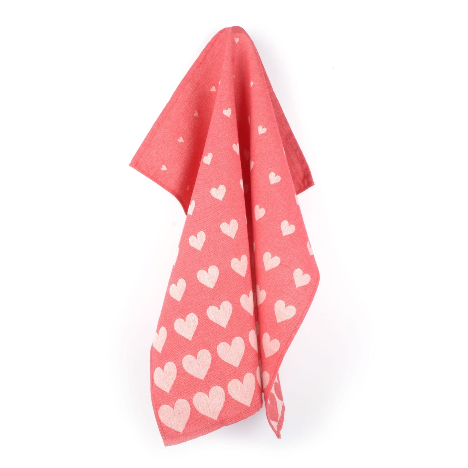 Een roze handdoek met hartjespatroon hangt aan een witte muur.