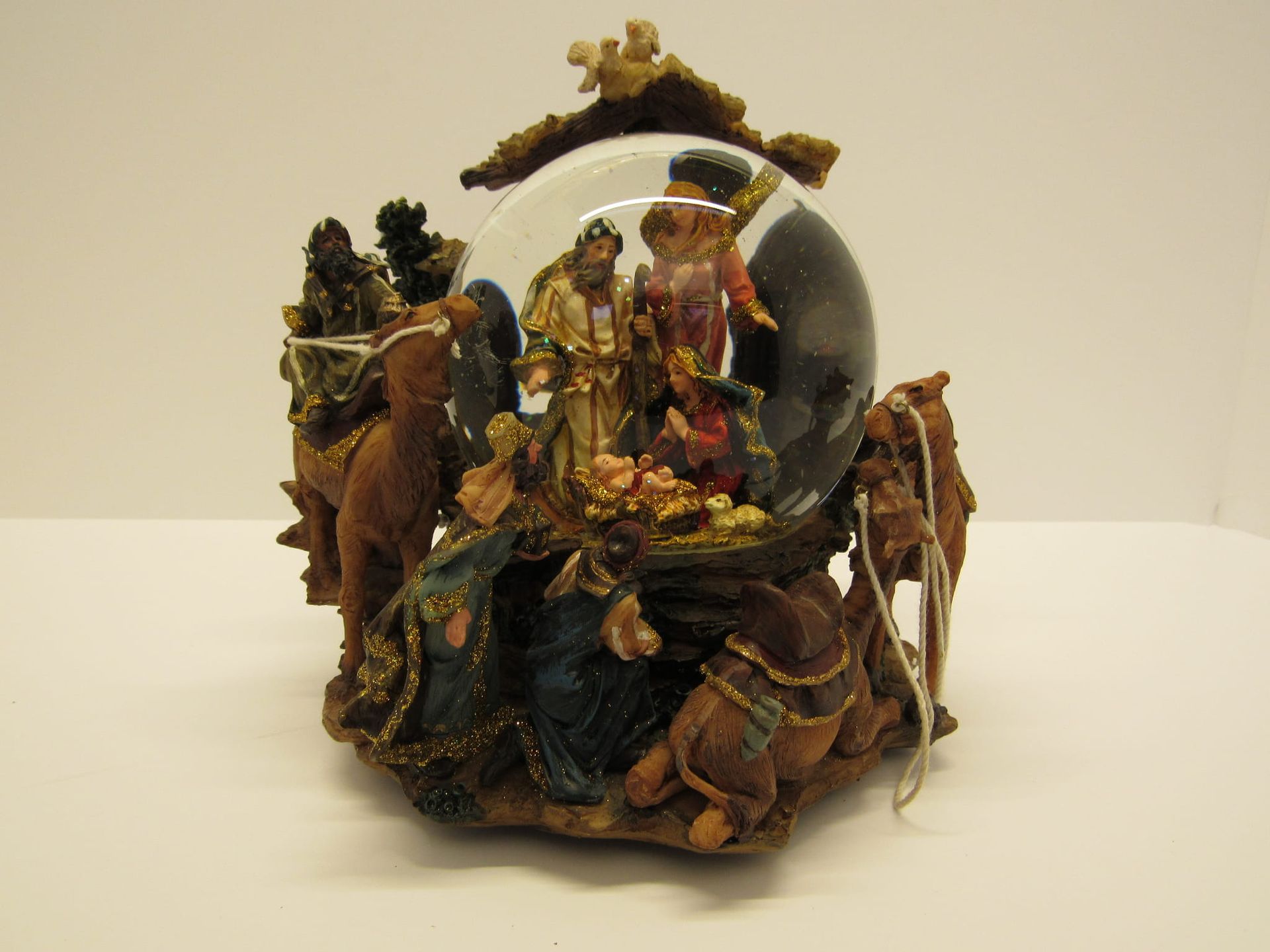 Sneeuwbol met kerststal, figuren, dieren en gouden accenten.