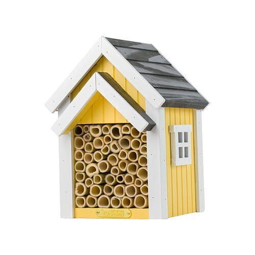 Geel-wit houten insectenhuis met een grijs dak, gevuld met bamboebuizen.