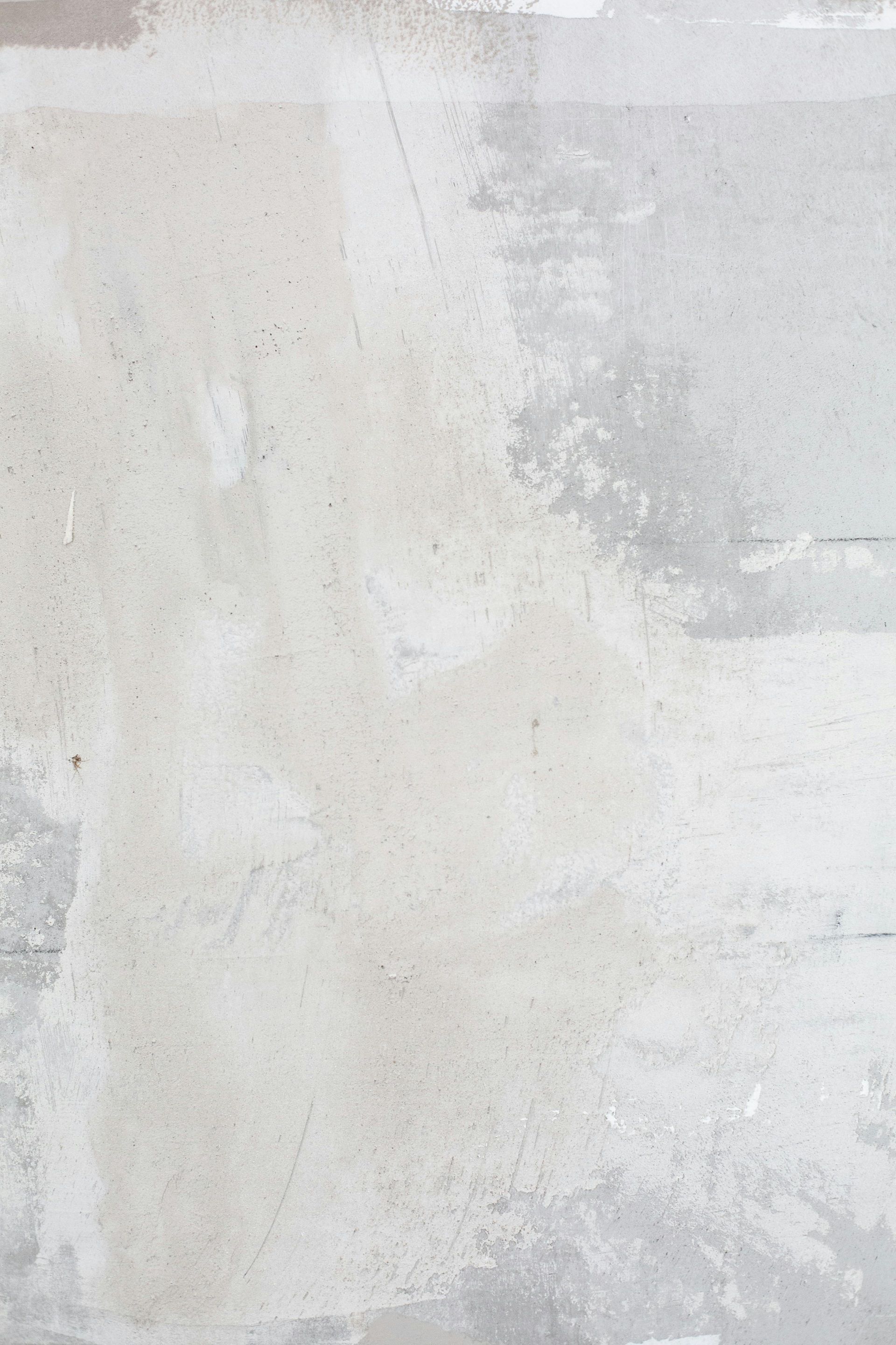 Abstract texture featuring layered, brush-stroked patches of muted beige, light gray, and soft white paint.