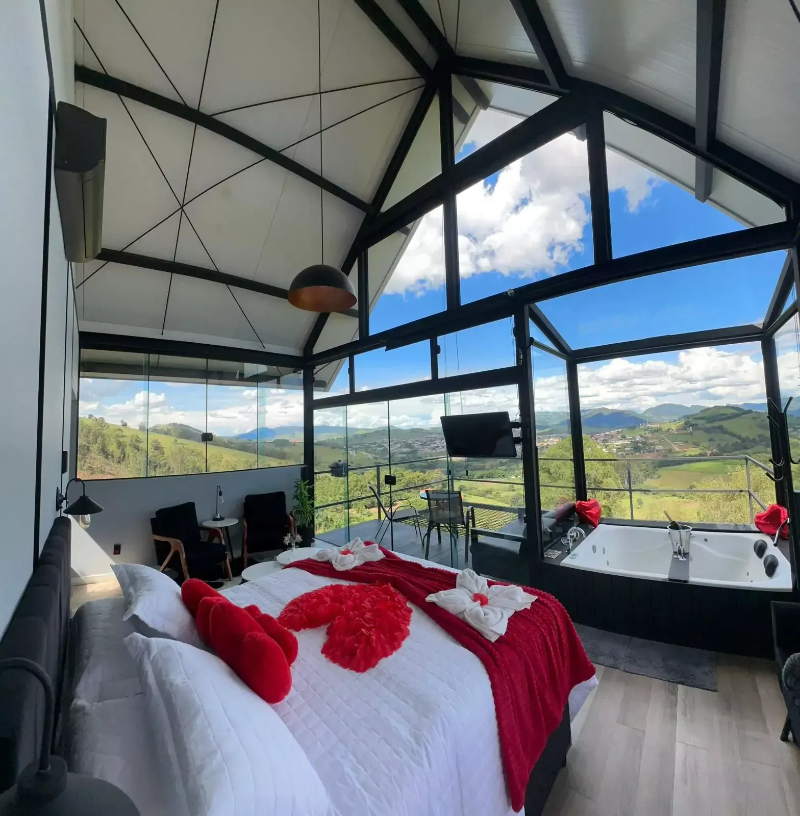 Um quarto com uma cama grande e uma banheira de hidromassagem. Chalé Pedra Negra