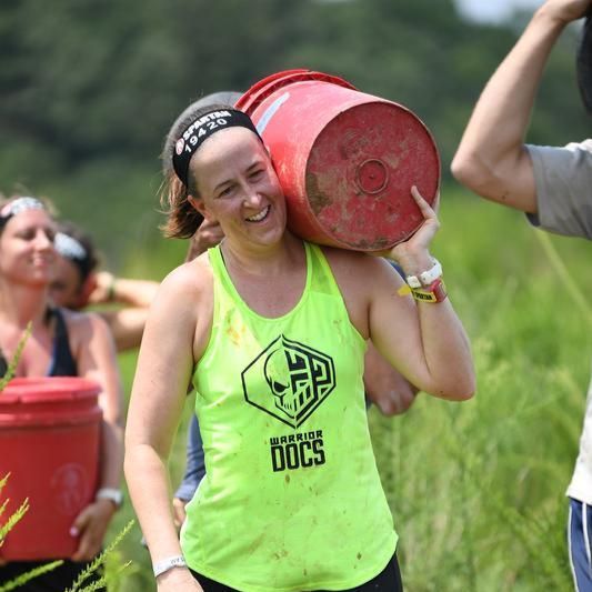 A woman wearing a green tank top with the word docs on it