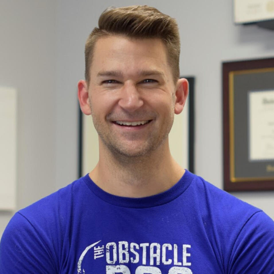 A man wearing a blue shirt that says the obstacle on it