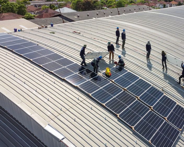 Group Of Workers Are Installing Solar Panels On The Roof Of A Building — High-Quality Solar Panels in Gunnedah
