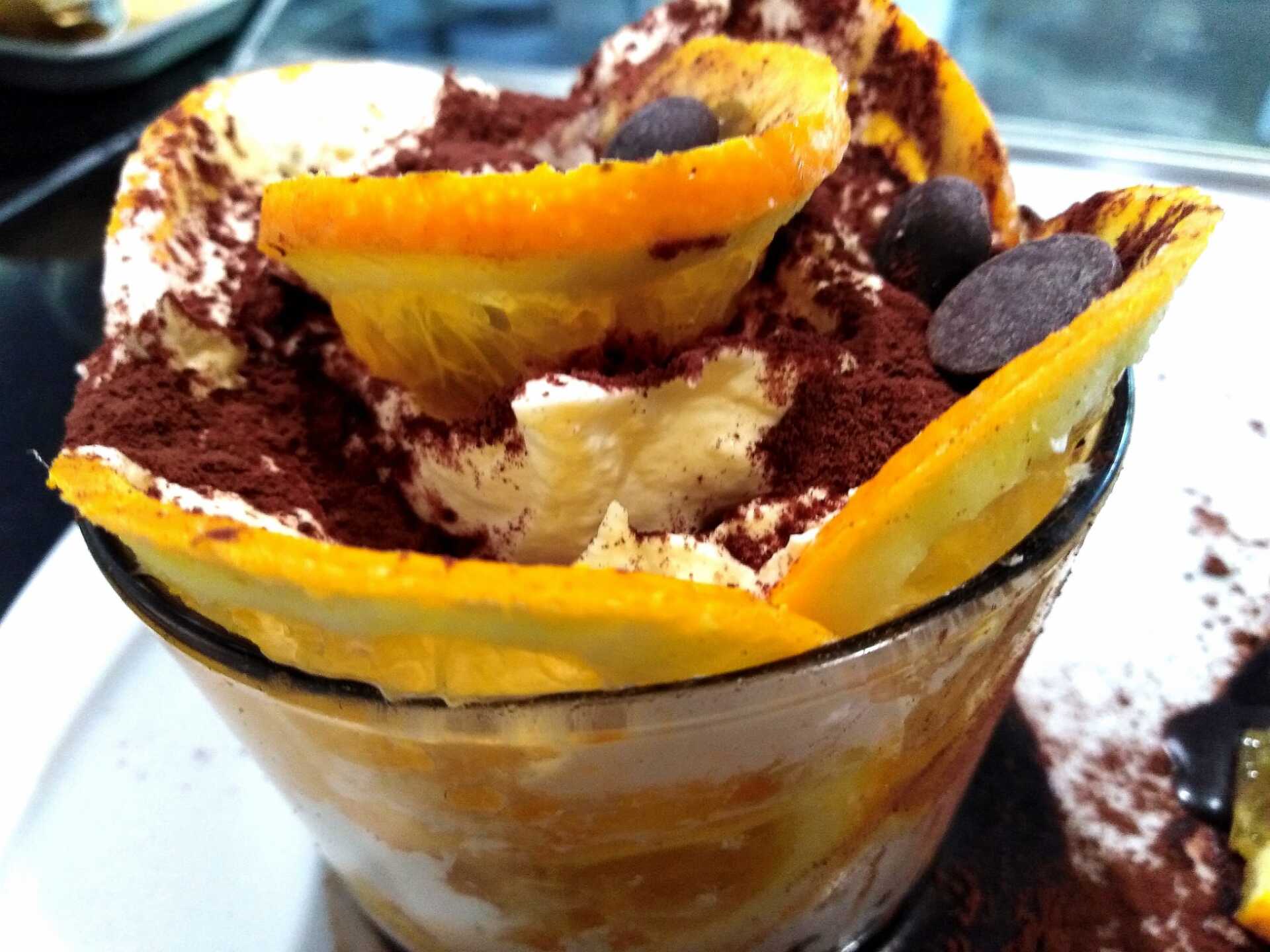 Un primo piano di un dessert con fette d'arancia e gocce di cioccolato