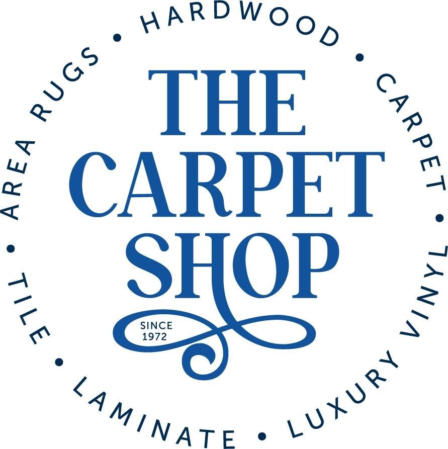 Logo for The Carpet Shop, established 1972, featuring blue text surrounded by a circle of flooring products.