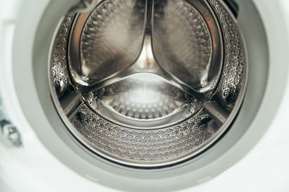 Inside view of a front-loading washing machine drum with metallic interior.