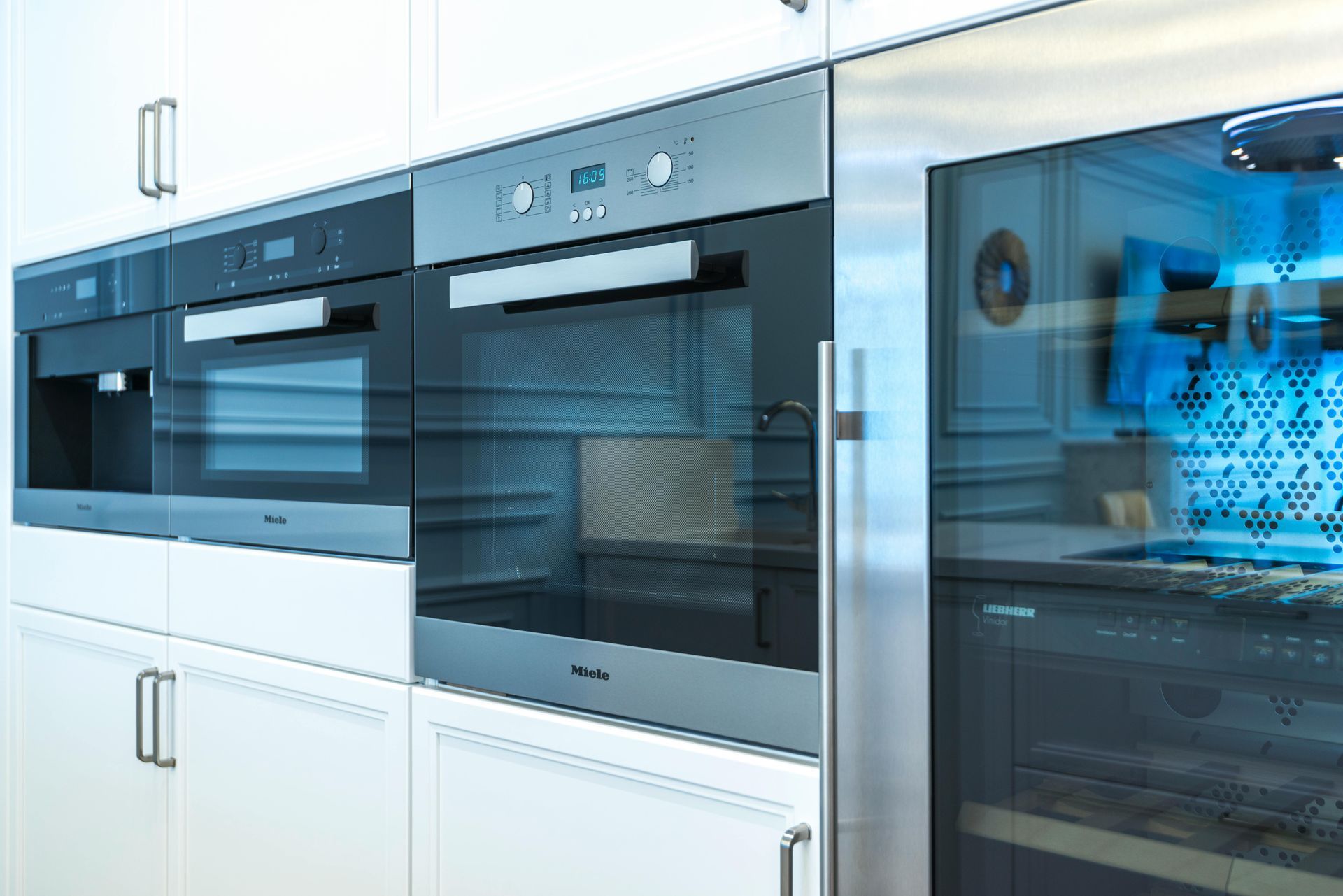 Modern built-in kitchen appliances with stainless steel and black glass fronts