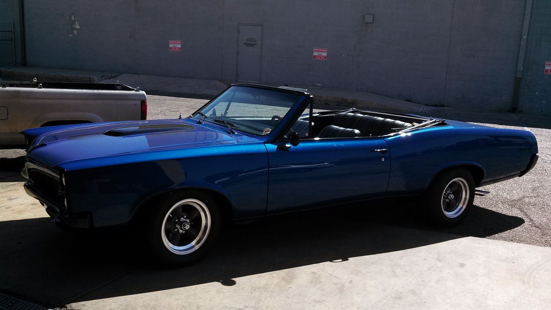 Blue classic convertible car parked outdoors in sunlight