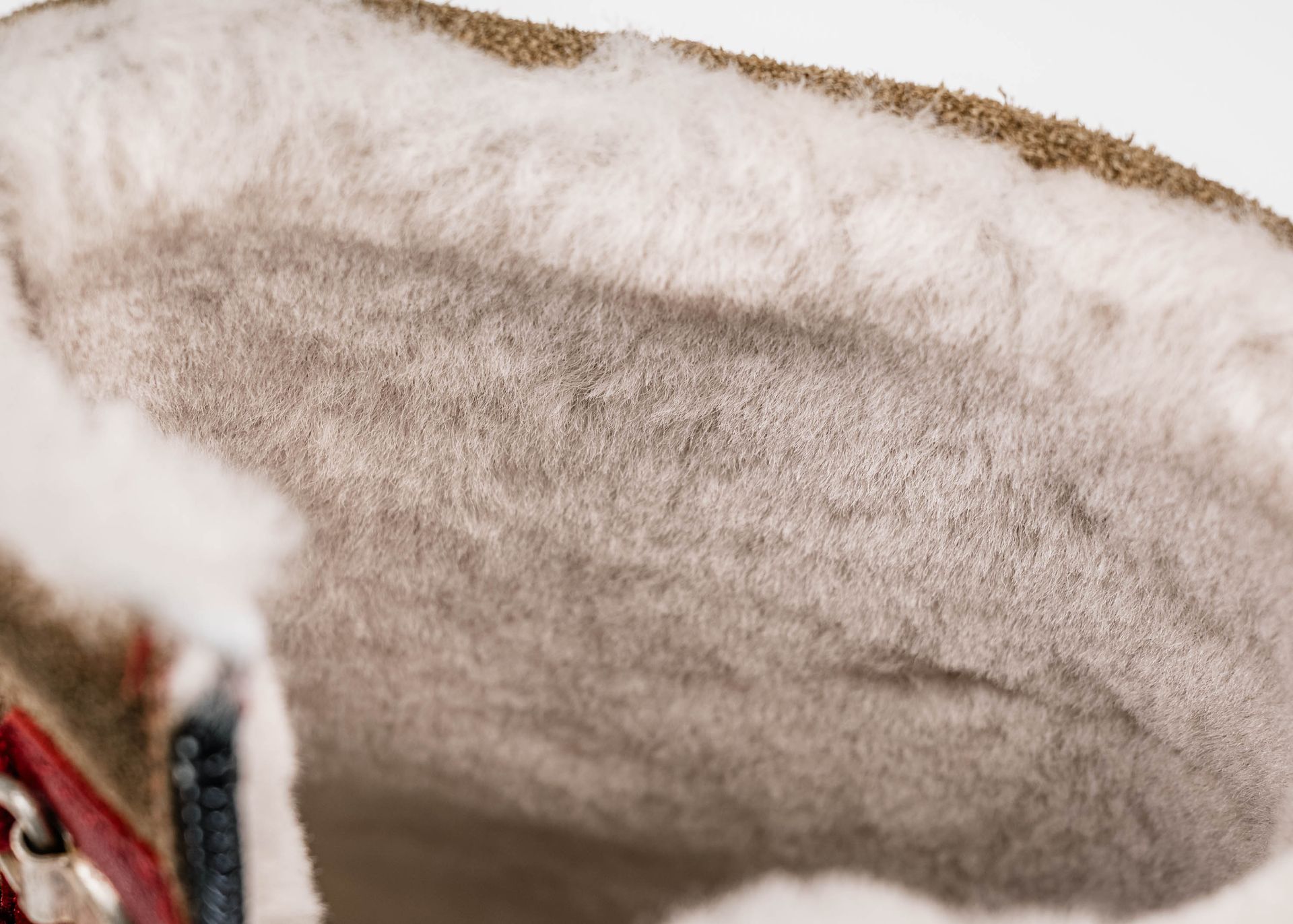 Gros plan de l'intérieur d'une botte avec doublure en peau lainée beige et cuir marron.