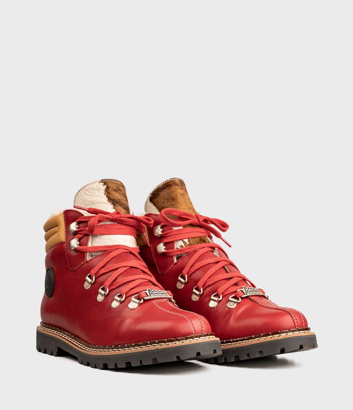 Bottes de randonnée en cuir rouge avec lacets rouges et doublure en fourrure marron.