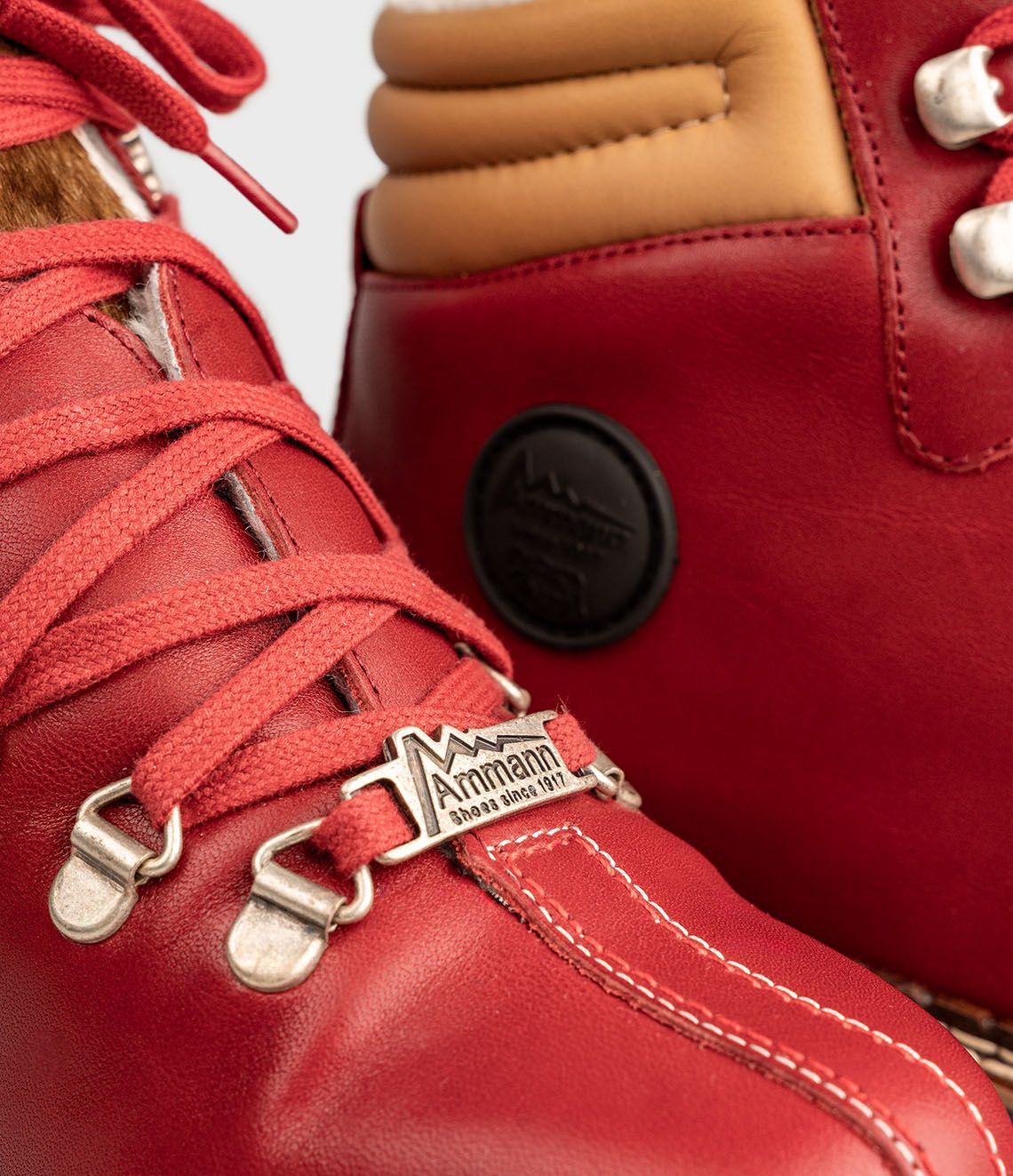 Bottes de randonnée en cuir rouge avec lacets rouges et doublure en fourrure marron.